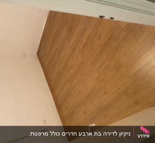 רצפת פרקט עץ נקייה ומטופחת בחדר ריק לאחר עבודת פוליש